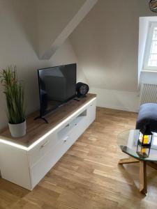 una sala de estar con TV de pantalla plana en un armario blanco en Harzer Kuschelnest en Halberstadt