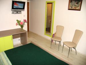 ein Wohnzimmer mit zwei Sesseln und einem Fernseher in der Unterkunft B&B Sidro in Vodice