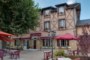 un bâtiment avec des tables et des chaises devant lui dans l'établissement Le Chalet de la Foret Logis Hôtel 3 étoiles et restaurant, à Vierzon