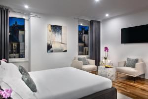 a white bedroom with a bed and a living room at Fellini Design Suites in Rome