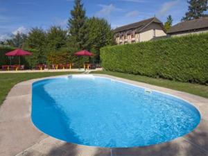 a large blue swimming pool in a yard at Le Chalet de la Foret Logis Hôtel 3 étoiles et restaurant in Vierzon