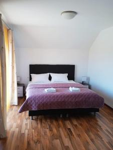 a bedroom with a bed with a purple comforter at Casa Panoramic in Turda