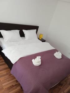 a bed with two white towels on a purple blanket at Casa Panoramic in Turda