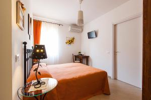 een slaapkamer met een bed en een tafel met een lamp bij Osteria da Cesare e Locanda in Castel San Pietro Terme