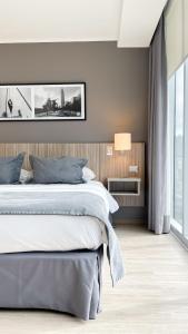 a bedroom with a large bed and a large window at Hotel Capital Bellet in Santiago