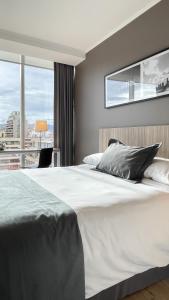 1 dormitorio con 1 cama grande y ventana grande en Hotel Capital Bellet, en Santiago