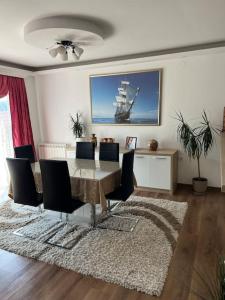 a dining room with a table and a ship on the wall at Montana House Njeguši in Cetinje