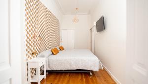 1 dormitorio con 1 cama y TV en la pared en APARTAMENTOS RAMAR 1, en Pravia