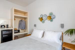 a bedroom with a white bed and a kitchen at Divino Suites in Fira