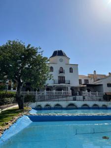 un edificio con piscina frente a un edificio en Costa Hispania 230, en Puerto Marino