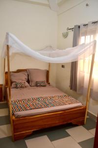 a bed with a canopy in a room at Porto-Novo logement lumineux et calme in Porto-Novo