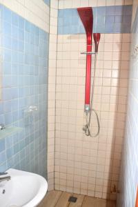 una doccia con soffione rosso in bagno di Porto-Novo logement lumineux et calme a Porto-Novo