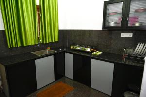 a kitchen with a sink and a green curtain at Besrauma Vythiri in Vythiri