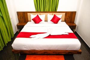 a bedroom with a large bed with red pillows at Besrauma Vythiri in Vythiri +19 photos