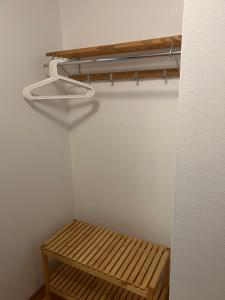 a closet with a wooden shelf and a wooden bench at Bed & Padel in Aavasaksa