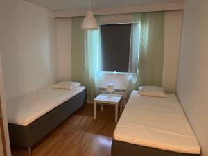 two beds in a small room with a window at Bed & Padel in Aavasaksa