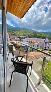 a balcony with a table and chairs and a view of a city at Hotel Dorado San Luis in San Luis