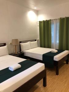- 2 lits dans une chambre avec des rideaux verts dans l'établissement Santander Pebble Beach Resort, à Santander