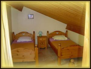 a bedroom with two beds and a table with a lamp at Gîte de la chanal 07 in Villevocance