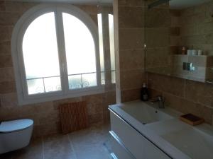 a bathroom with a tub and a sink and a window at Jardin de la ciotat 5mn des plages in La Ciotat