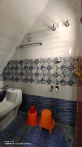 ein Bad mit Waschbecken, WC und Fliesen in der Unterkunft YUGA GUEST HOUSE in Kuttālam