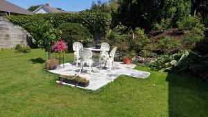 a garden with a table and chairs in the grass at Modern basement apartments Stavanger, Sola airport, Kjerag, Preikestolen in Stavanger +5 photos