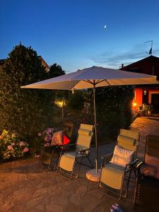 - un ensemble de chaises et d'un parasol sur la terrasse dans l'établissement Casa Serenella, à Piazzola sul Brenta