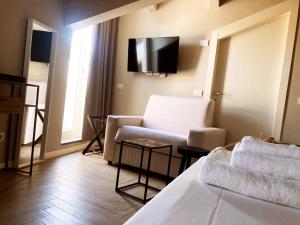 a living room with a couch and a tv on the wall at Gatto Bianco Rooms 42 in Bergamo