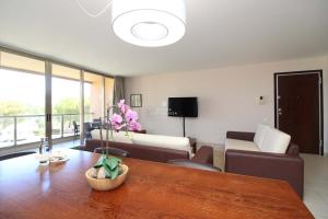 een woonkamer met een bank en een tafel bij Apartment Villa das Lagoas - By Dalma Portuguesa in Galé