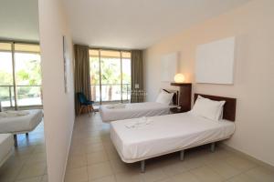 een hotelkamer met twee bedden en een tafel bij Apartment Villa das Lagoas - By Dalma Portuguesa in Galé +21 foto's