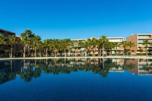 een groot zwembad met palmbomen en gebouwen bij Apartment Villa das Lagoas - By Dalma Portuguesa in Galé