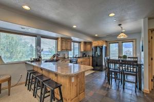 a kitchen with wooden cabinets and a island with bar stools at Eden Condo Less Than 5 Mi to Nordic Valley Ski Resort in Eden