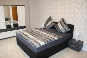 a bedroom with a bed with pillows and a mirror at Gästehaus Rheinburgenblick in Kestert
