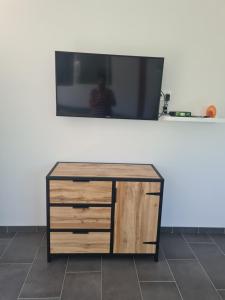 a dresser with a tv on top of a wall at Studio à la campagne sans vis à vis in Boulin