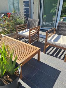 2 sedie e un tavolo in legno su un patio di Studio à la campagne sans vis à vis a Boulin