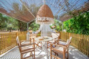 um pátio com uma mesa e cadeiras sob uma pérgola em THIRES Guesthouse em Vasilikos