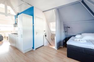 a bedroom with a bed with a blue head board at Bluys Apartment in Zandvoort