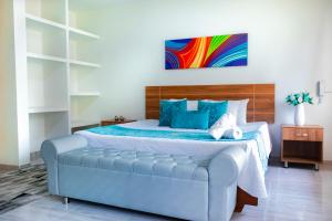 a bedroom with a king sized bed with blue pillows at Hotel Plaza Real in Santa Rosa de Cabal