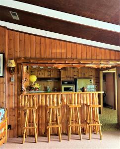 a kitchen with a bar with stools around it at Somewhere In Time - RETRO SPACIOUS COTTAGE with PRIVATE SANDY BEACH in Wiarton