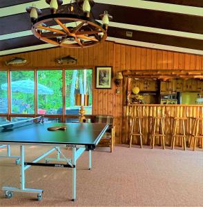 a ping pong table in a room with a bar at Somewhere In Time - RETRO SPACIOUS COTTAGE with PRIVATE SANDY BEACH in Wiarton