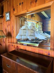 a large sail boat in a mirror in a room at Somewhere In Time - RETRO SPACIOUS COTTAGE with PRIVATE SANDY BEACH in Wiarton
