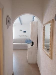 uma sala de estar com um sofá branco e um espelho em La Casetta Cannigione em Cannigione