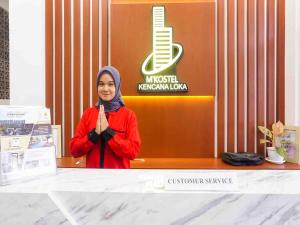a woman standing in front of a counter with her hands up at Collection O 91226 M'kostel Syariah in Serang