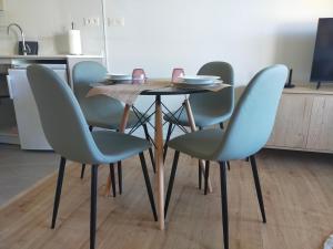 a table with four chairs and a table with plates on it at Apartamento Sofía in Llanes