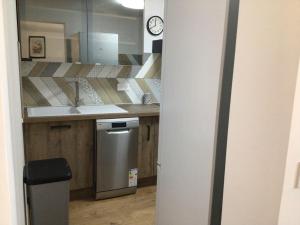 a kitchen with a sink and a clock on the wall at Escapade côte d'Azur in Saint-Aygulf