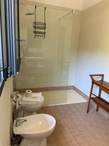 a bathroom with a toilet and a glass shower at Agriturismo SS Annunziata in San Vincenzo