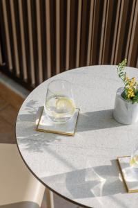 une table blanche avec un verre d'eau sur elle dans l'établissement Preveza City Comfort Hotel, à Prévéza