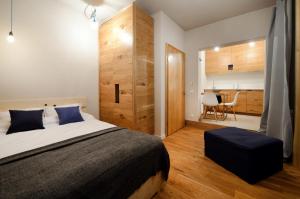 a bedroom with a large bed and a table at Alpini Apartamenty in Zakopane