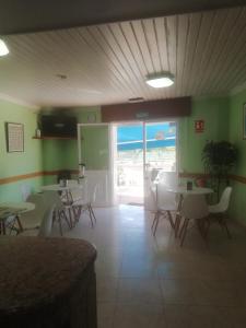 un restaurante con mesas y sillas en una habitación en PENSION CARMEN **, en Sanxenxo