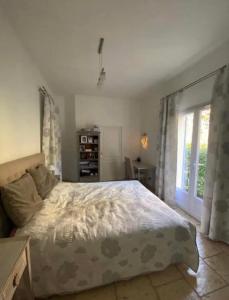 sypialnia z dużym łóżkiem i oknem w obiekcie Villa du Soleil en Provence sur le Domaine du Golf de Pont Royal w mieście Mallemort